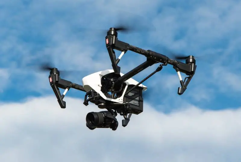 A black and white camera flying in the air.