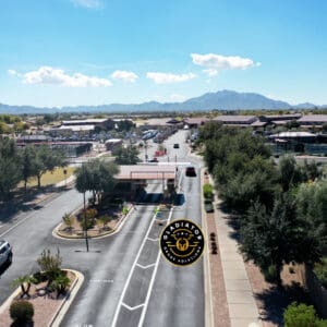 Aerial view of a residential neighborhood with streets lined with houses and vehicles, with mountains in the background on a clear day.