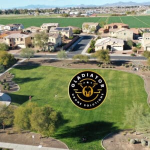 Aerial view of a suburban area with a large green park, playground, and adjacent houses, marked by a gladiator pest control logo watermark.