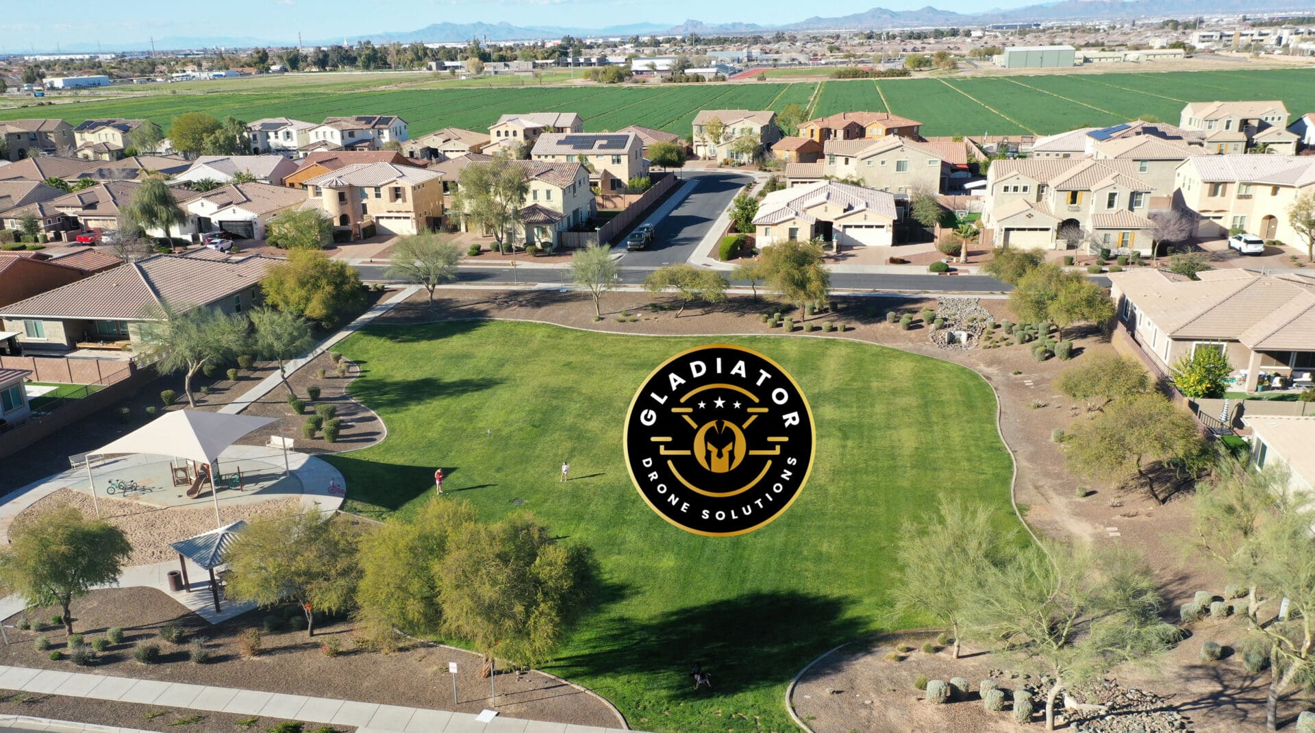 Aerial view of a suburban area with a large green park, playground, and adjacent houses, marked by a gladiator pest control logo watermark.